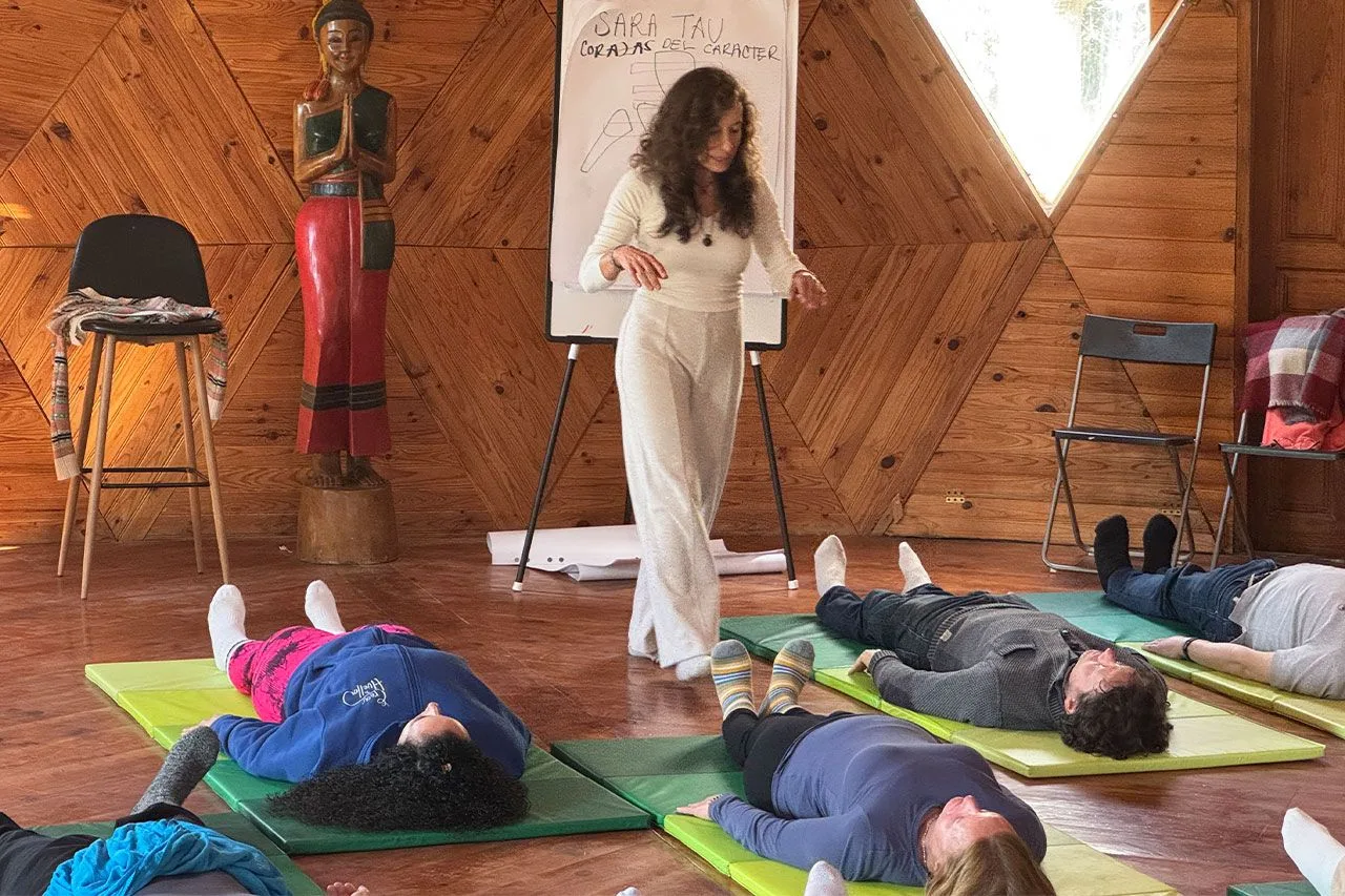 Sara Tau guiando una clase del Método TAU con alumnos tumbados en esterillas
